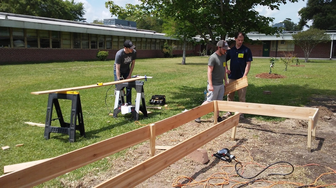 Adult volunteers building boxes for the school garden
