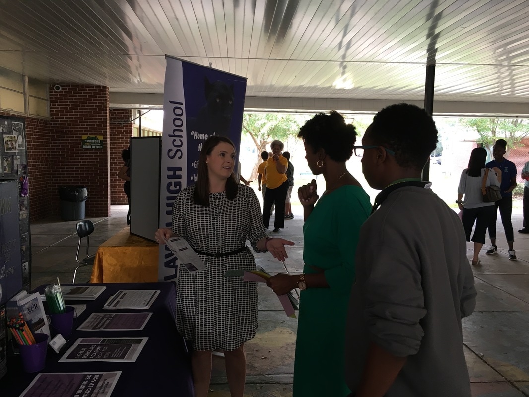 A student and a parent speak with a high school representative.