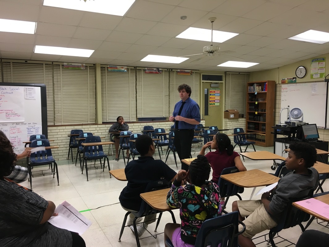 Parents listen to a teacher's open house presentation. 
