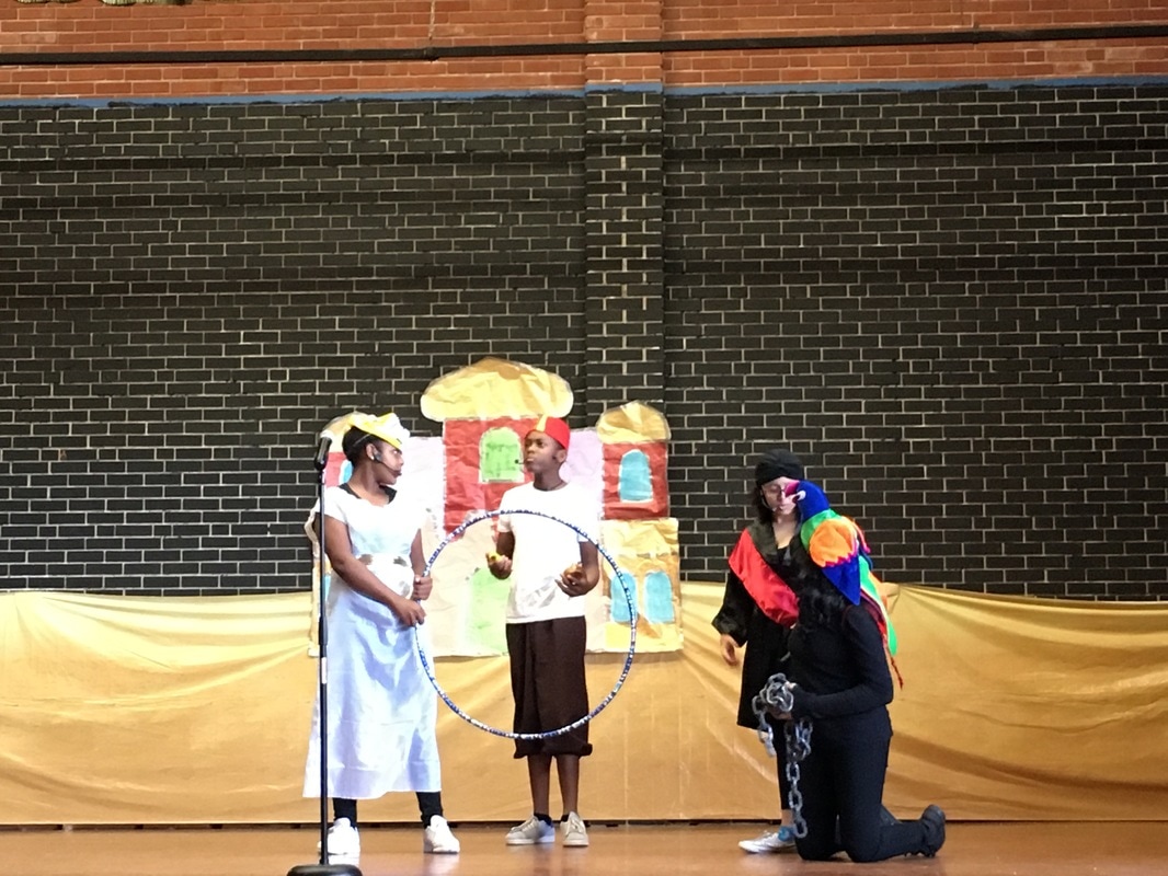 A boy dressed as Aladdin is speaking to three students.