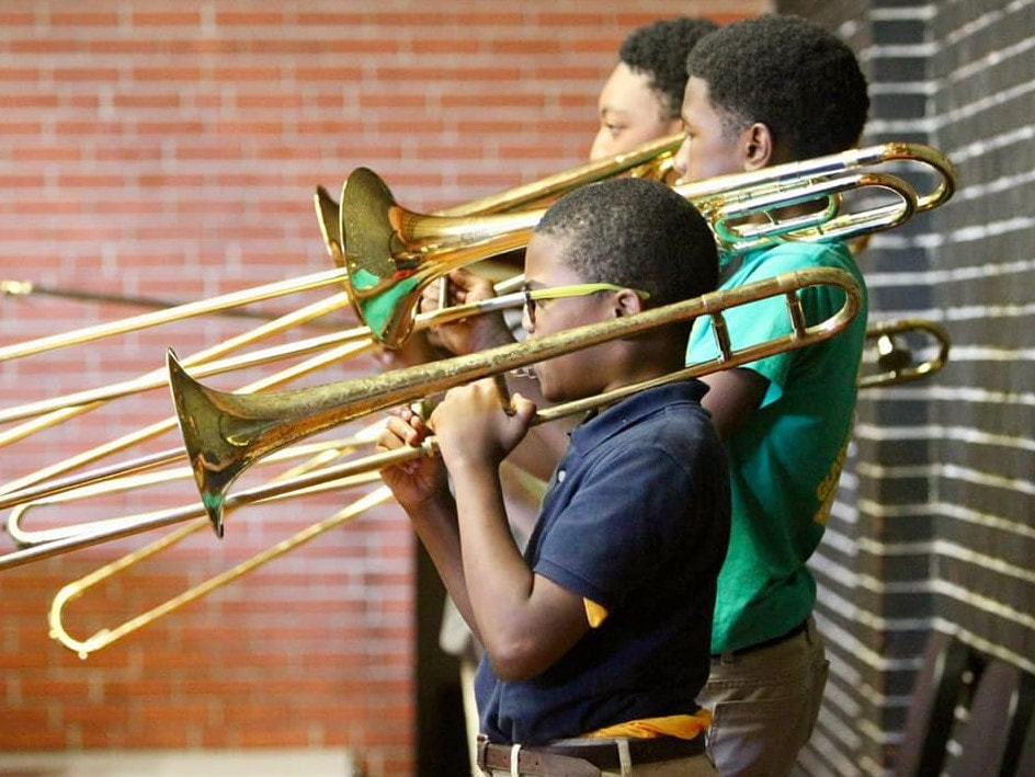 Three students playing trumpets