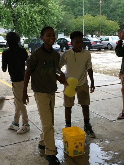Two male students holding a sponge during a relay race