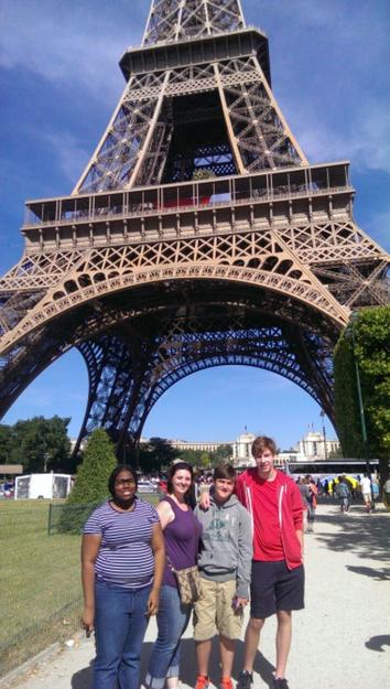 Students and adults in front of the Eiffel Tower.