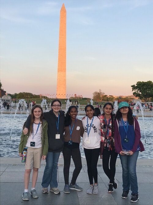 A group of six female students standing in front of the Washington Monument